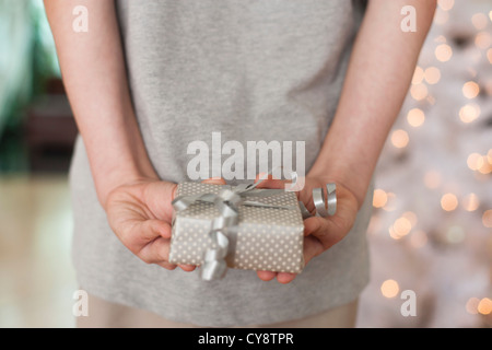 Girl holding gift behind back Banque D'Images