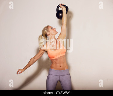 Femme faire son entraînement Crossfit kettlebell Banque D'Images