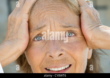 Senior woman holding head, en détresse sur le visage de l'expression Banque D'Images