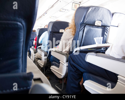 Les passagers assis dans une compagnie aérienne commerciale Vol, USA Banque D'Images