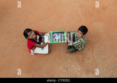 Village indien fille et garçon AVEC UN SEUL MONDE écrit sur un tableau noir dans un village de l'Inde rurale. L'Andhra Pradesh, Inde Banque D'Images