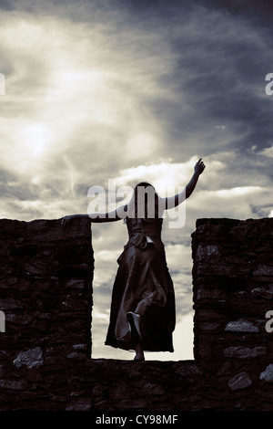 Une femme sur un mur jaillissant Banque D'Images