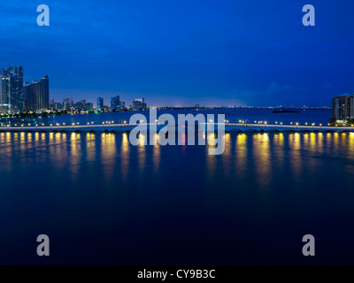 Vue sur Biscayne Boulevard/bâtiments, les toits de Venise et feux de pont à péage du pont-jetée à la tombée de la nuit, Miami Beach Floride USA. Banque D'Images