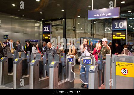 Les voyageurs arrivant en train et de quitter la plate-forme à la gare de Kings Cross LONDRES, ROYAUME UNI Banque D'Images