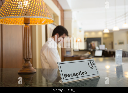 Réception de l'hôtel avec une table et réceptionnistes sur un arrière-plan Banque D'Images