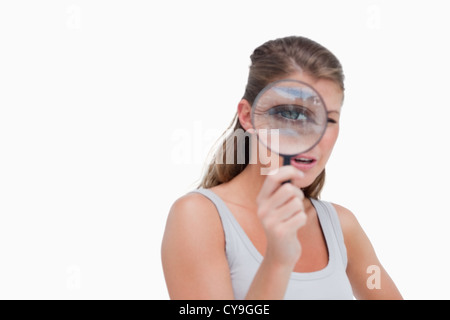 Jeune femme à travers une loupe Banque D'Images