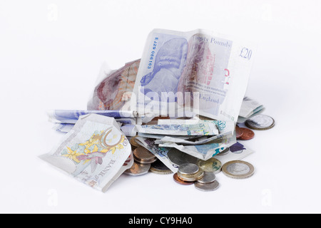 Une pile de pièces de monnaie britanniques et des notes sur un fond blanc. Banque D'Images