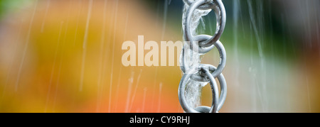 L'eau de pluie à partir d'un toit jaillit un ménage chaîne pluie lors d'une tempête. Format panoramique. L'espace pour copier. Banque D'Images