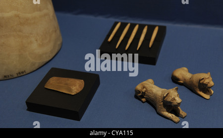 Jeu de deux morceaux d'ivoire en forme de lion, un pot de fin d'albâtre, racloir silex et cinq flèches d'os. D'Abydos. Banque D'Images