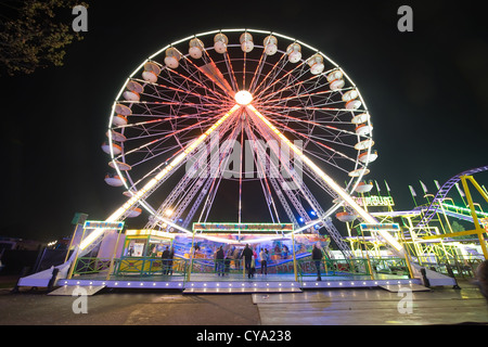 Une grande roue dans la soirée dans un parc d'attractions Banque D'Images