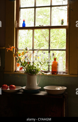 Un vitrage 12 fenêtre vous permet d'une lumière douce dans une chambre dans une vieille maison de campagne dans le Maine. Banque D'Images