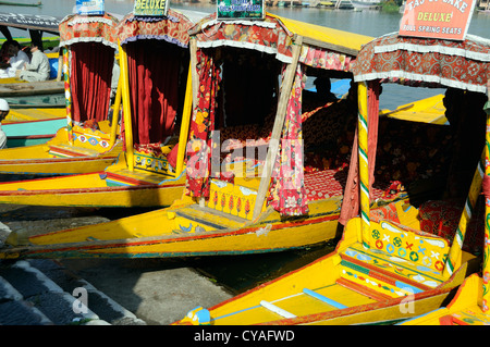 Shikaras jaune, de petits bateaux en bois taxi de l'eau, attendre que les clients sur les rives du lac Dal. Srinagar, au Cachemire. L'Inde Banque D'Images