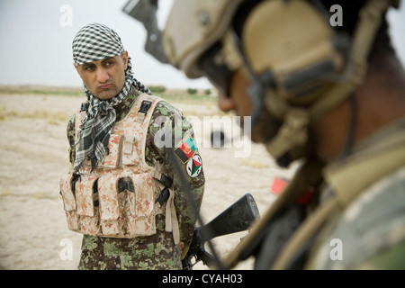 Un soldat de l'armée nationale afghane, un membre de la force de coalition montres utiliser sa radio au cours d'une force de sécurité nationale afghane ont mené des patrouilles afin d'empêcher l'ennemi de la liberté de mouvement en-Khuk Khak e-safed, dans la province de Farah, l'Afghanistan, oct. 30, 2012. fnsa ont pris les devants dans les opérations de sécurité, avec les forces de la coalition à titre de mentors, d'apporter la sécurité et la stabilité au peuple de la République islamique d'afghanistan. Banque D'Images