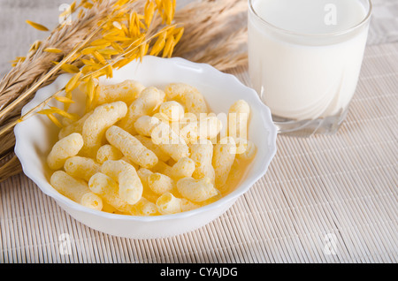 Le petit-déjeuner. Un verre de lait et le corn sticks Banque D'Images