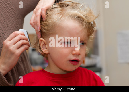 Combinant un triste à quatre ans pour les lentes des cheveux du garçon Banque D'Images