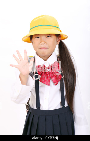 Smiling little asian schoolgirl montrant sa main Banque D'Images