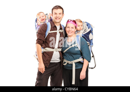 Une famille heureuse avec des sacs à dos de randonnée posant isolé sur fond blanc Banque D'Images