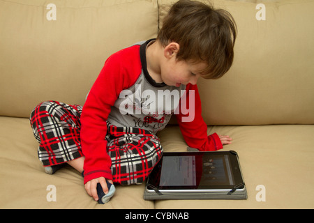 Un garçon de 3 ans navigue sur internet sur un iPad Banque D'Images