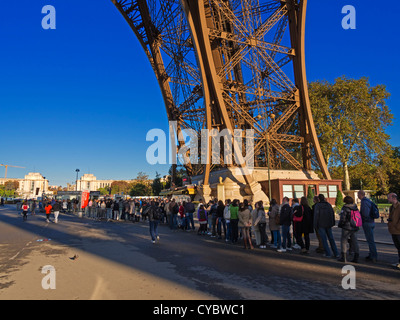 Les touristes la file d'attente de la Tour Eiffel, Paris. Les longues files d'attente sont typiques pour le plus célèbre monument de Paris, même en automne. Banque D'Images