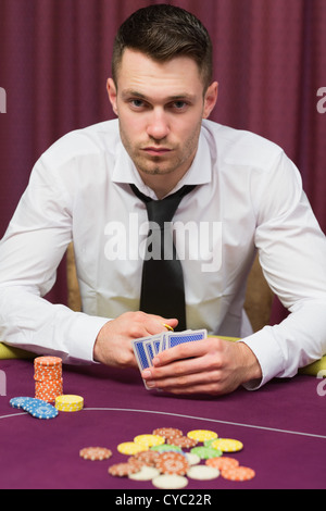 L'homme assis à table de poker Banque D'Images