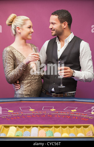 Couple drinking champagne at poker table Banque D'Images