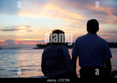 Couple au bord de regarder le coucher du soleil en soirée de célébrations Mallory Square key west florida usa Banque D'Images