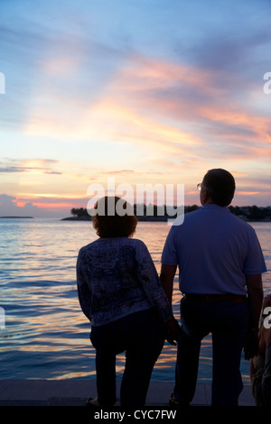 Couple au bord de regarder le coucher du soleil en soirée de célébrations Mallory Square key west florida usa Banque D'Images