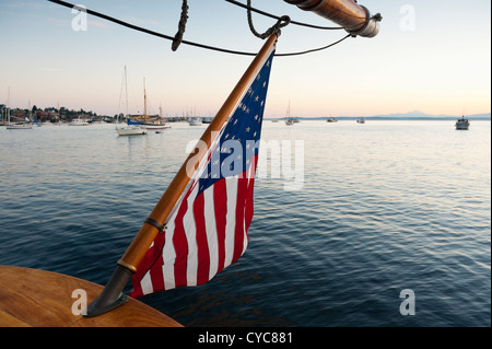 Au lever du soleil, à bord du grand navire 'zodiac' à l'arrêt à la poupe de brandir le drapeau américain dans la brise à Port Townsend. Banque D'Images
