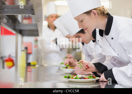 Finition du chef des salades dans leur classe culinaire Banque D'Images
