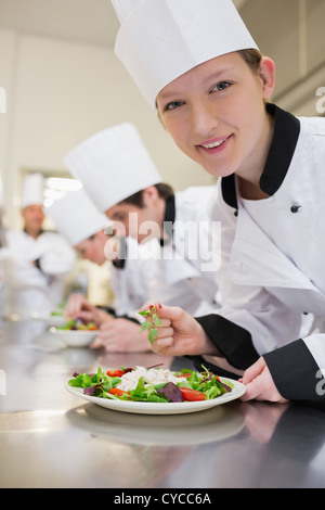 Smiling chef preparing salad en classe culinaire Banque D'Images
