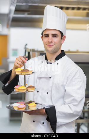 Baker holding tiered cake tray Banque D'Images