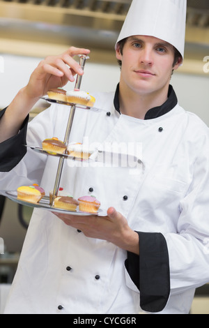 Baker présentant plusieurs niveaux bac gâteau Banque D'Images