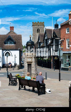 Un couple assis sur un banc de Much Wenlock, Shropshire, England, UK. Banque D'Images