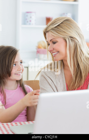 Fille pointing at laptop with mother Banque D'Images