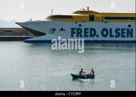 Fred Olsen ferries hydroptère avec les hommes dans la petite barque à l'avant à Puerto de las Nieves Gran Canaria Îles Canaries Espagne Banque D'Images