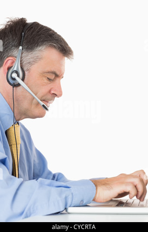 Businessman with headset écrit sur l'ordinateur portable Banque D'Images