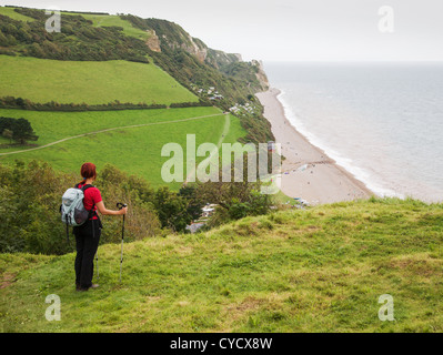 Une femelle walker avec vue sur la plage de Branscombe Bay dans le sud du Devon Banque D'Images