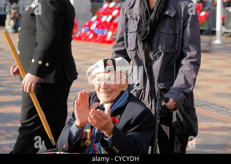 Un vieux soldat dans un fauteuil roulant à un défilé du souvenir des mains. Banque D'Images