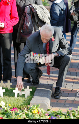 Un homme de mettre une croix dans le sol autour de la salle du Souvenir 2011 de Birmingham. Banque D'Images