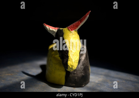 Une sculpture de papier d'un taureau peint en blanc et jaune s'affiche dans un atelier d'art populaire mexicain à Mexico City, Mexique Banque D'Images