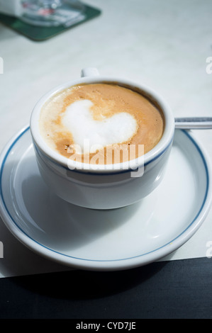 Cafe con leche avec forme de coeur dans le lait moussé sur le dessus Banque D'Images