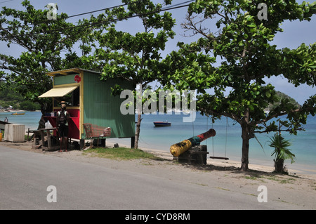 Ciel bleu bayside Beach road voir les arbres, cannon, fruits légumes de boutique, Harvey Vale, Tyrrel Bay, Carriacou, West Indies Banque D'Images