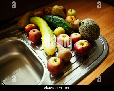 Collection biologique : sélection aléatoire de fruits et légumes cueillis à maturité de la maison jardin - pomme, poire, melon, concombre Banque D'Images