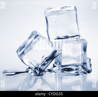 Fusion de trois cubes de glace sur une table en verre Banque D'Images