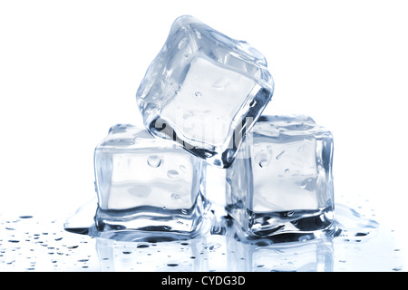 Fusion de trois cubes de glace sur la table en verre. Sur fond blanc Banque D'Images