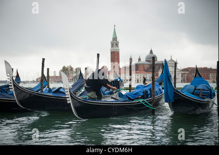 Gondolier écoule son Gondola se préparer pour les touristes, Venise, Italie. Banque D'Images