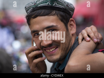 Jeune homme au téléphone, Hotan, la région autonome ouïghoure du Xinjiang, Chine Banque D'Images