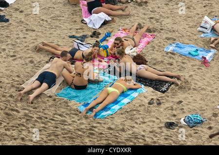 Les Pays-Bas, Scheveningen, près de La Haye ou en néerlandais : Den Haag. Les jeunes gens en train de bronzer sur la plage. Aerial Banque D'Images