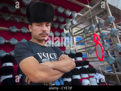 Jeune homme musulman Doppi vente Chapeaux, Marché du Village d'Opale, la région autonome ouïghoure du Xinjiang, Chine Banque D'Images