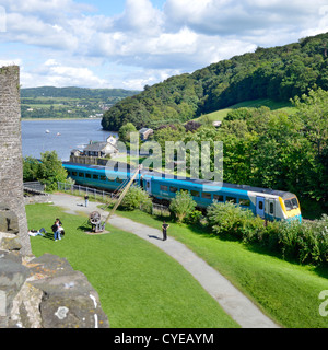 Holyhead à la ligne à côté de murs du château avec le train arriva à propos de traverser Stephenson a pont sur la rivière Conwy Banque D'Images